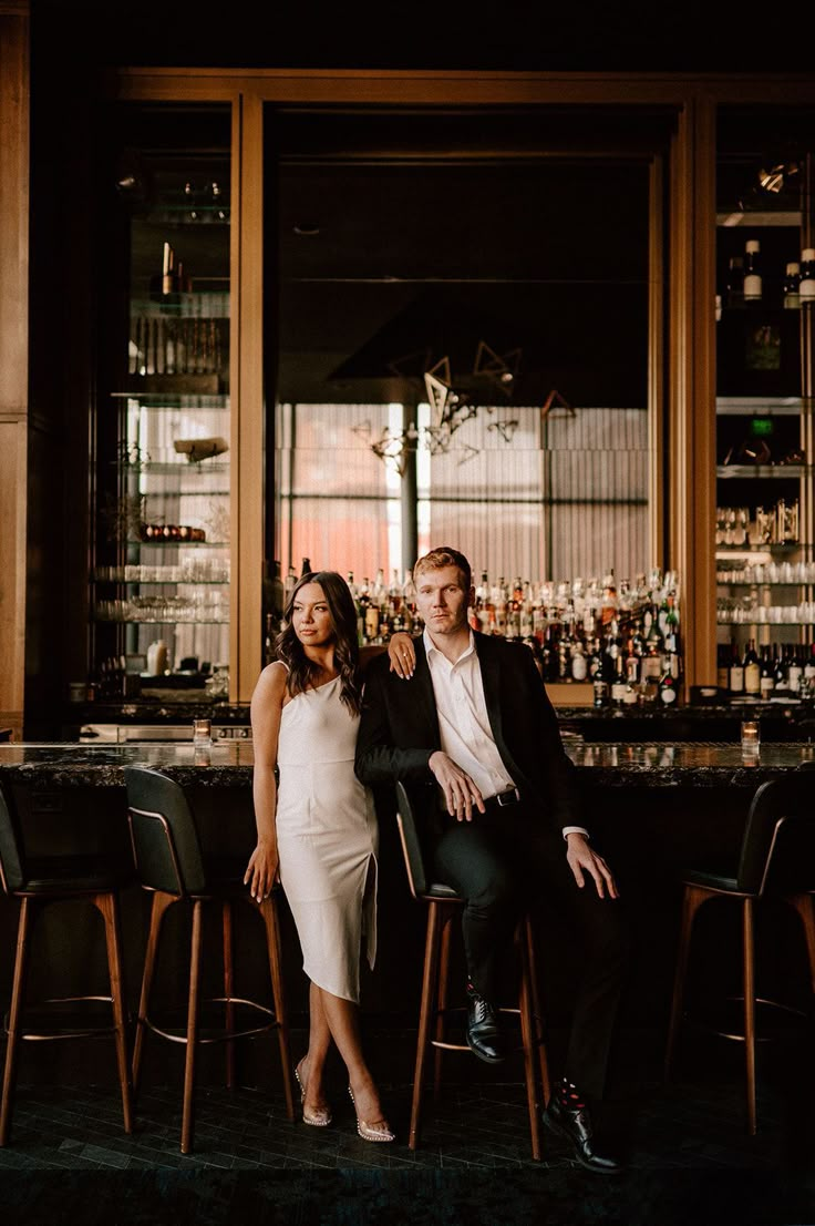 a man and woman sitting at a bar