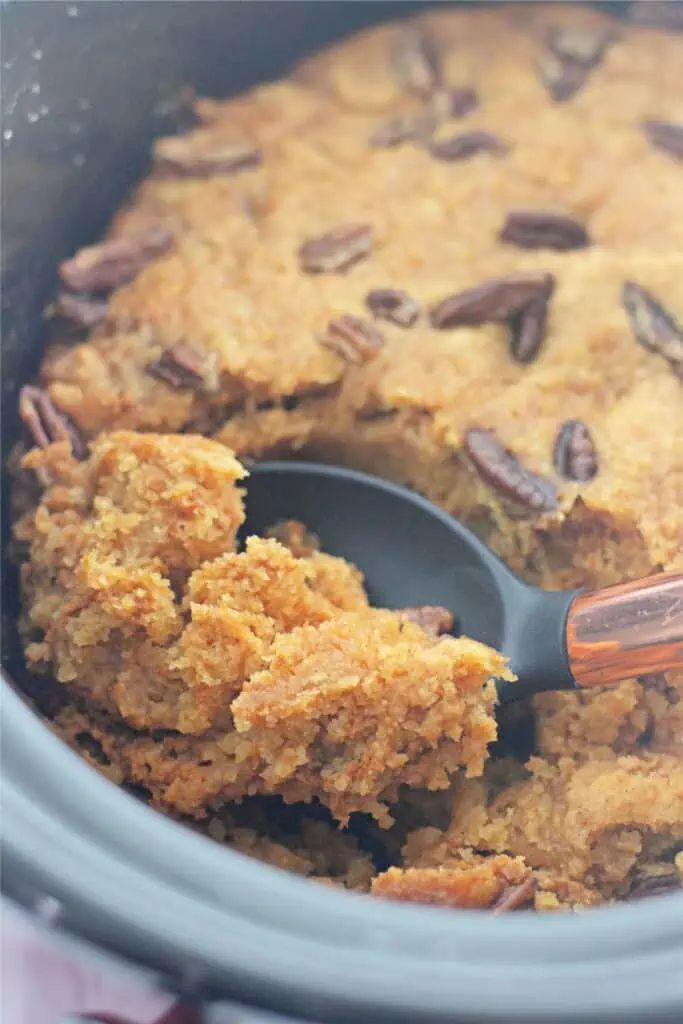 a crock pot filled with some food and a spoon in the middle of it