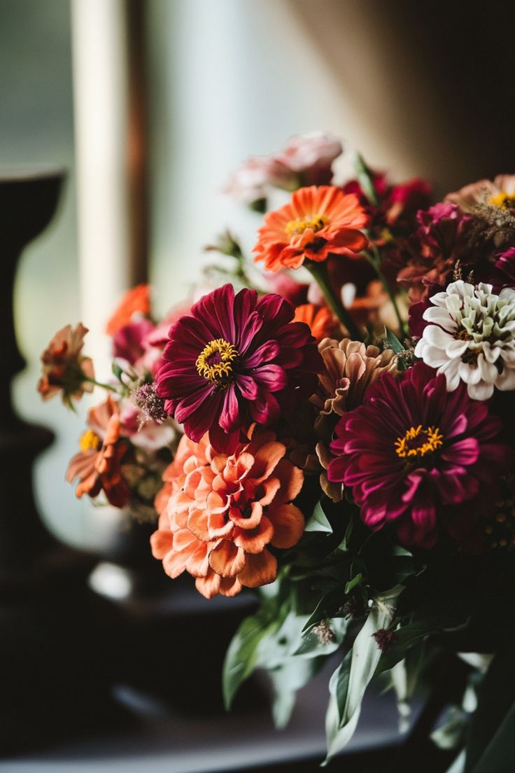 a vase filled with lots of different colored flowers