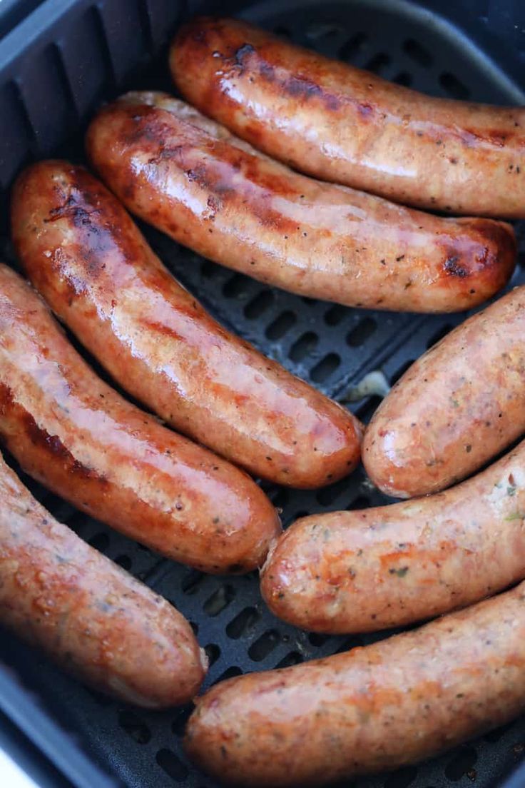 several sausages are being cooked in an air fryer