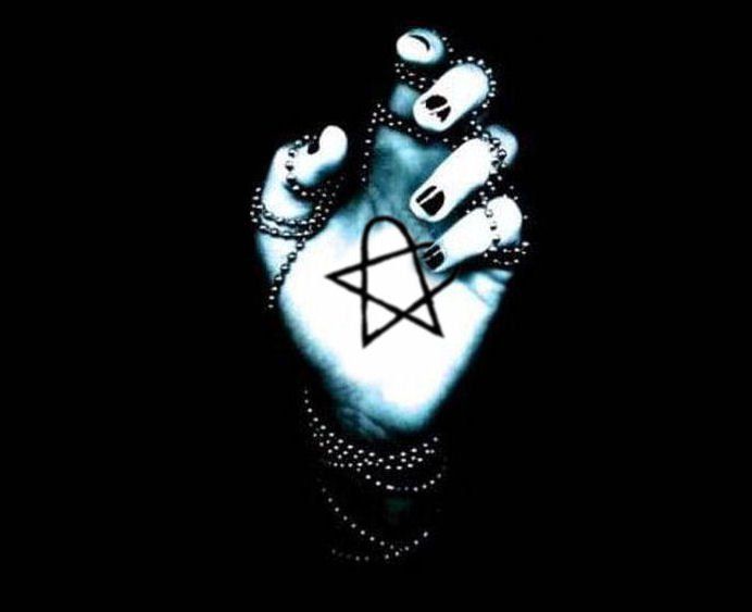 a person's hand with a pentagramil on it, in the dark