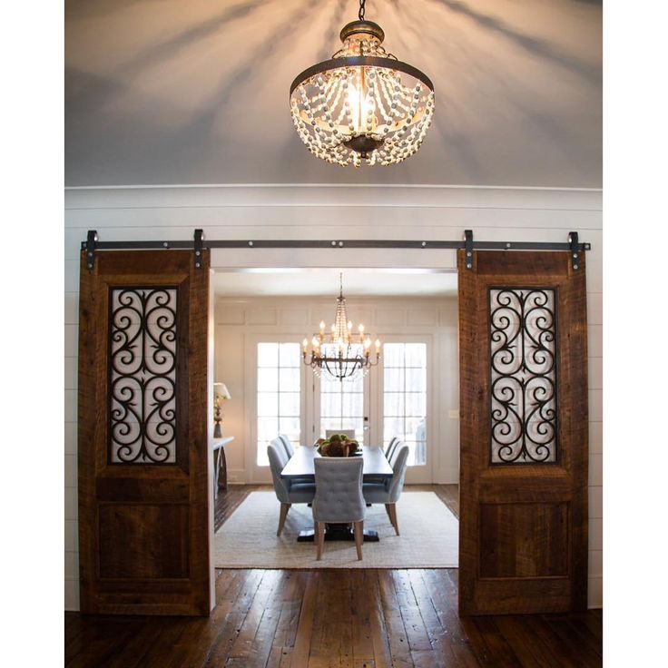 an open door leading to a formal dining room with chandelier and table in the center