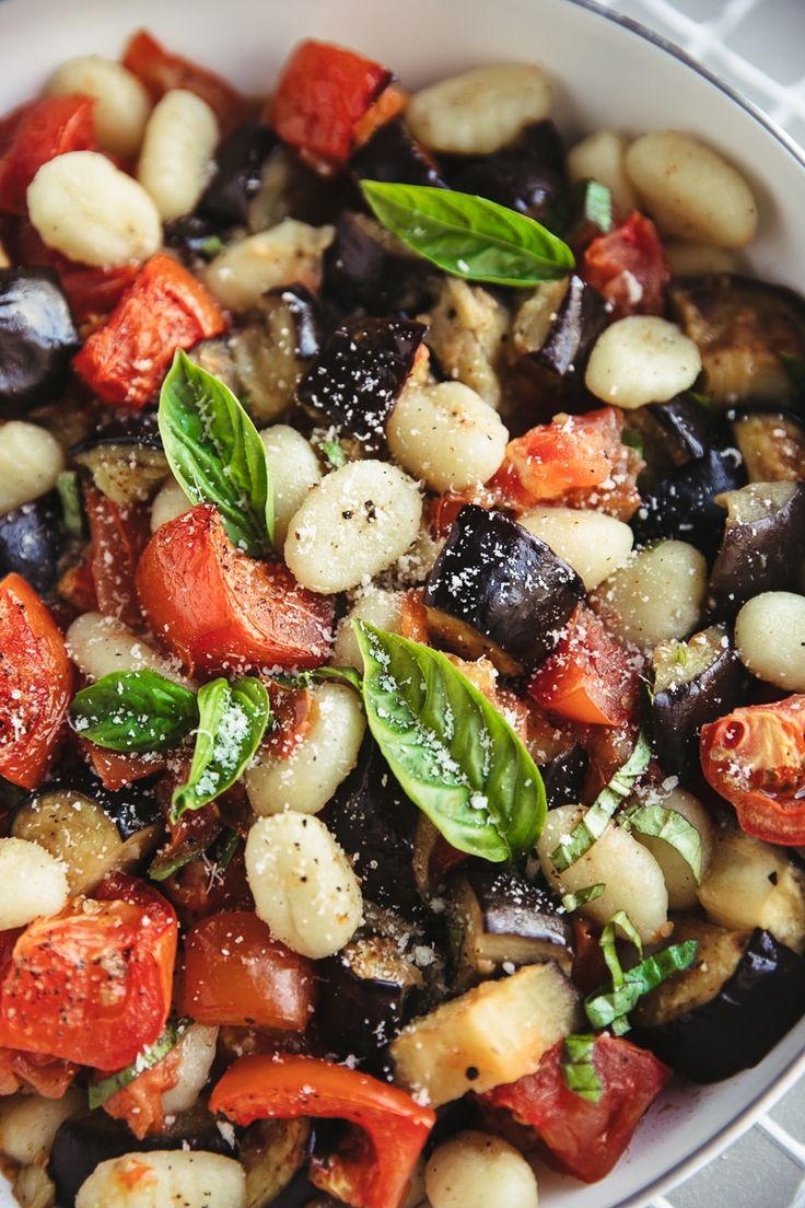 a white bowl filled with lots of different types of food on top of a table