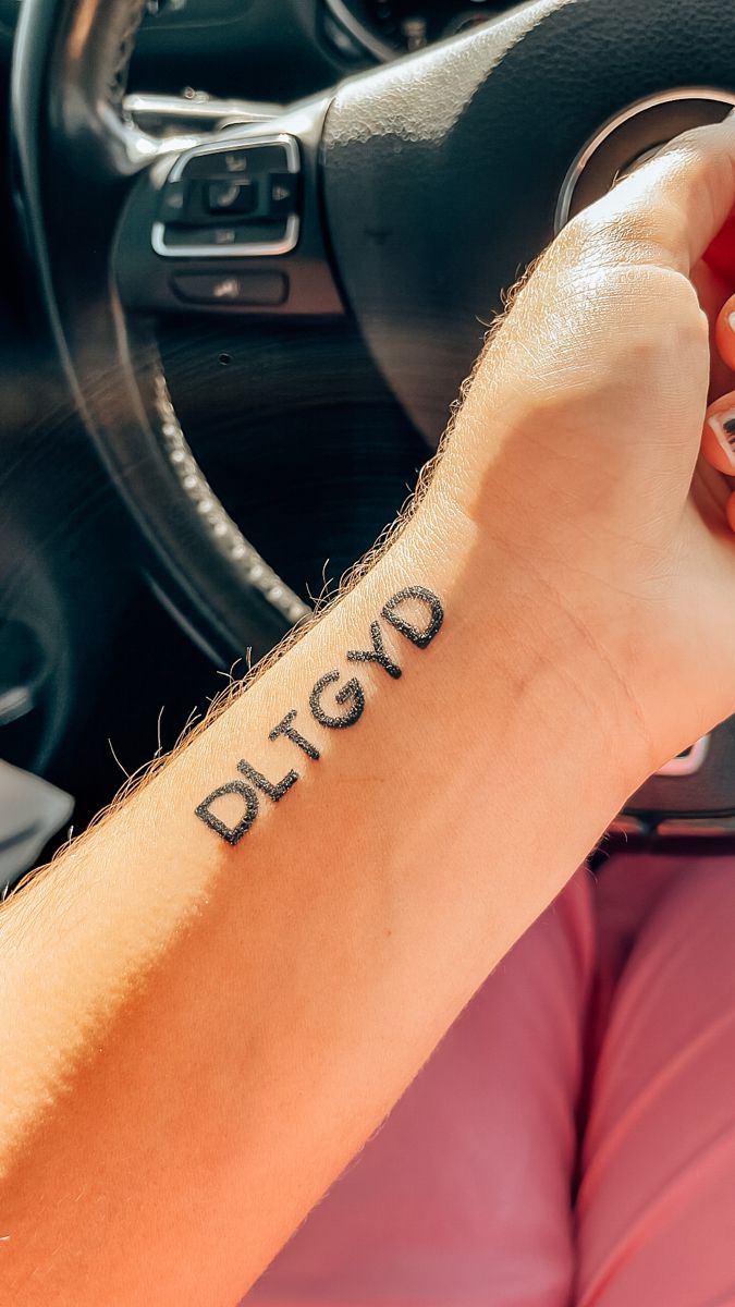 a person with a tattoo on their arm driving a car