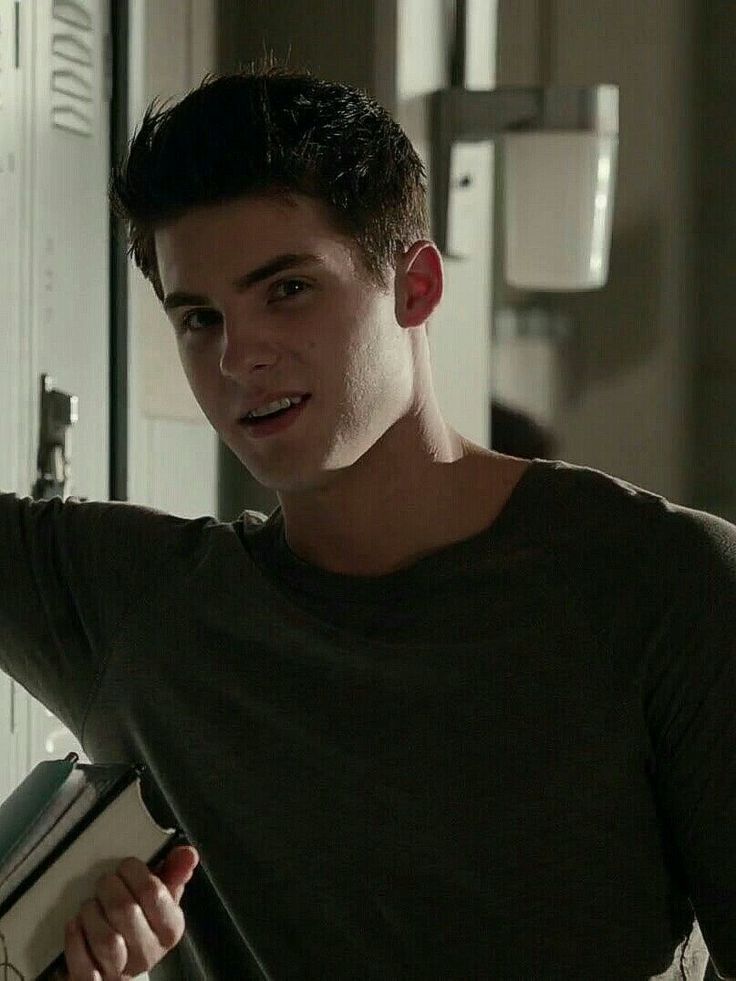 a young man standing next to a locker