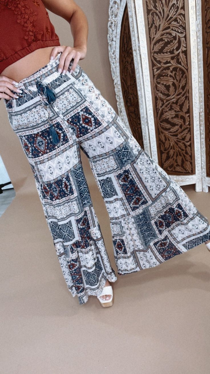 Hit the streets of style wearing these Midnight Daydream Printed Wide leg Pant! With boho designs and wide legs that taper down as you walk, you'll be sure to turn heads no matter the occasion. Make 'em your go-to for a unique look! Boho Pants Wide leg Elastic waistband Flare Flowy fit Measurements: Measured laying flat - 4” stretch in the waistband S: Waist: 26” | Hip: 42” | Rise: 12” | Inseam: 29 1/4” M: Waist: 28” | Hip: 44” | Rise: 12 1/4” | Inseam: 29 3/4” L: Waist: 30” | Hip: 46” | Rise: 12 1/2” | Inseam: 30 1/4” Model Specs: Emily is wearing a size small in the photo. How will this item fit you? Check out our MODEL SPECS(Typical Sizing - Karli: S-Size 5/26 - 5ft 2in, Emily: S-Size 3/25 - 5ft 5in, Syd: L/XL- Size 15/ - 5ft 8in)Need help with sizing? No problem! Join our VIP group on Hippie Boho Print Vacation Bottoms, Casual Boho Print Wide Leg Harem Pants, Casual Wide Leg Boho Print Harem Pants, Bohemian Boho Print Pants For Vacation, Summer Boho Print Harem Bottoms, Boho Print Harem Bottoms For Summer, Boho Print Hippie Pants For Vacation, Wide Leg Boho Print Pants For Vacation, Flowy Boho Print Bottoms For Vacation