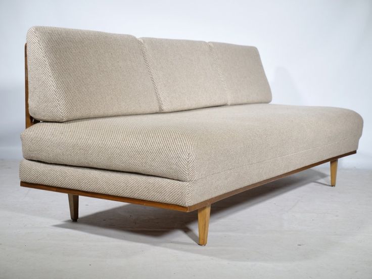 a beige couch sitting on top of a white floor