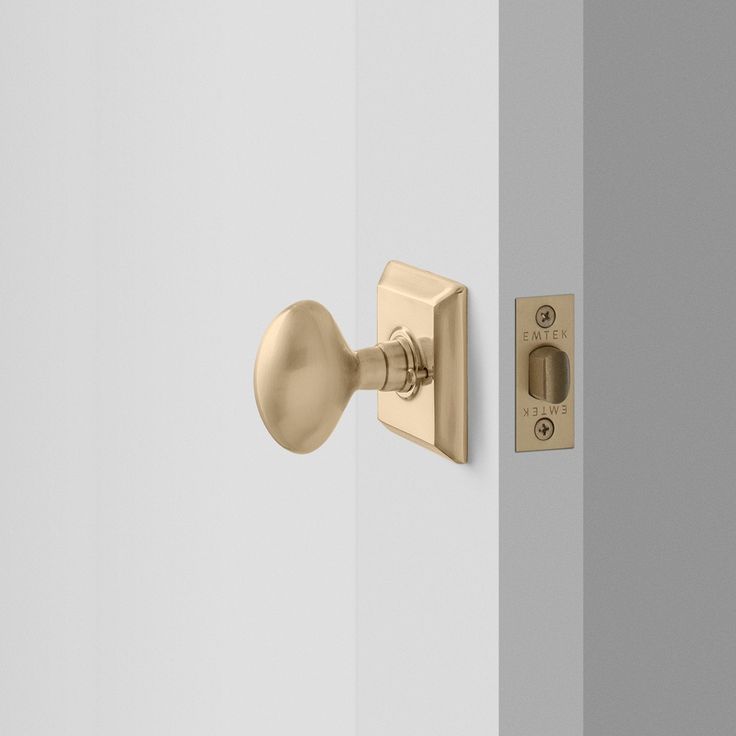 an open door with a handle and knob on the outside wall, in front of a light gray wall