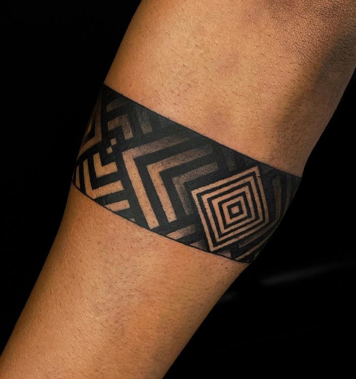 a man's arm with a black and white tattoo design on the wrist,