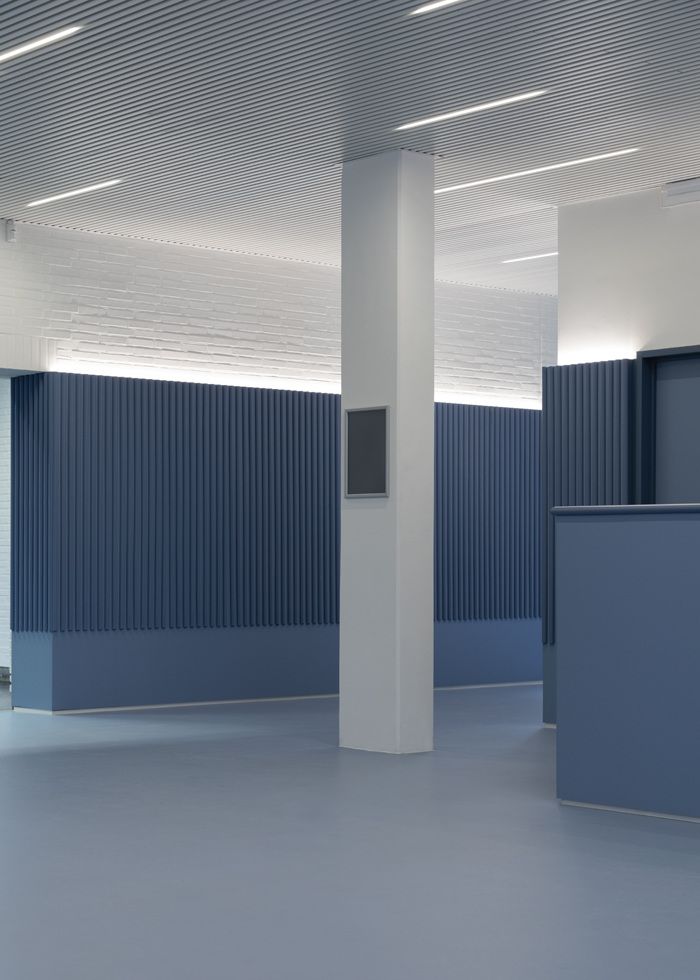 an empty room with blue walls and white columns