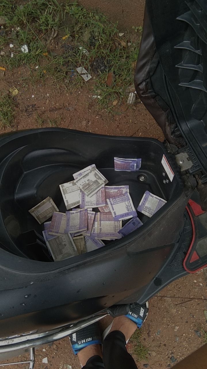 a pile of money sitting in the back of a motorcycle seat next to a bag