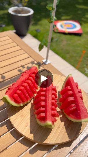 slices of watermelon on a wooden platter with an umbrella in the background