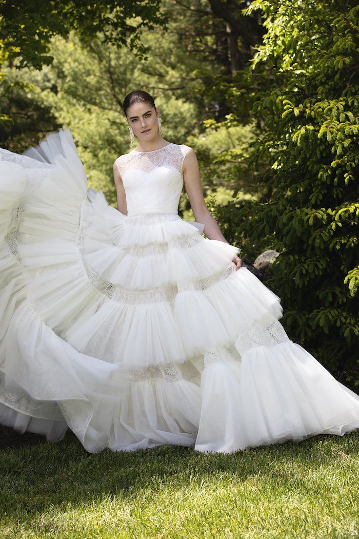 a woman in a white wedding dress standing on the grass