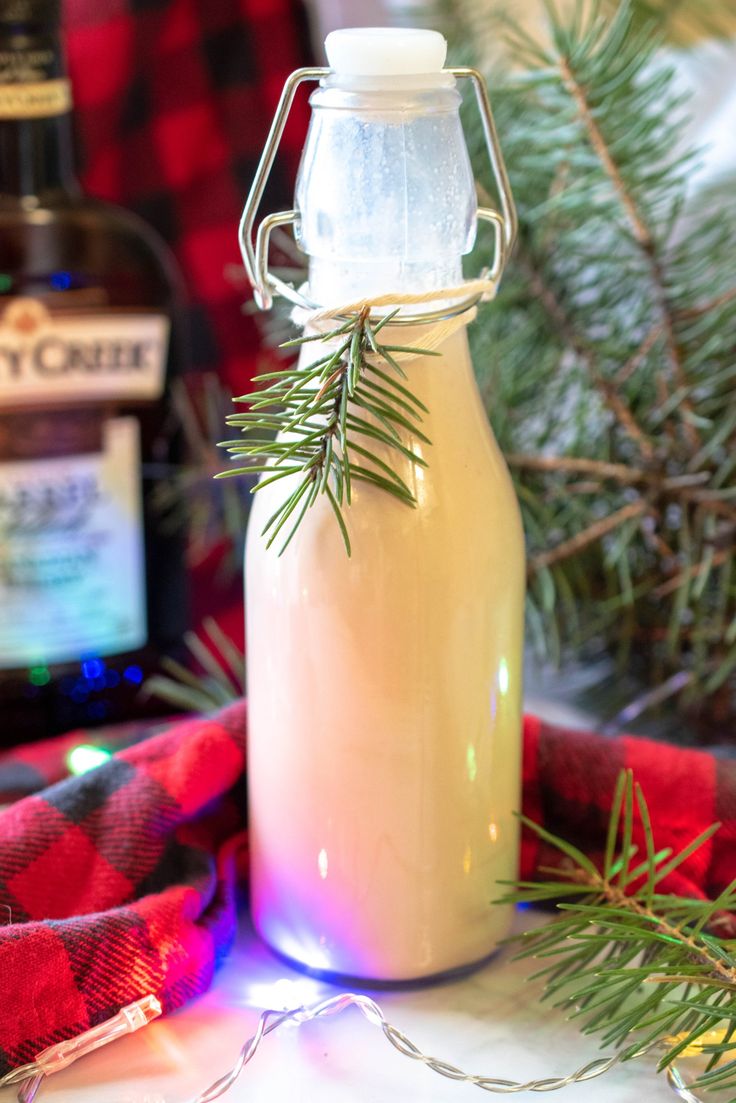 a bottle filled with liquid sitting on top of a table next to a christmas tree