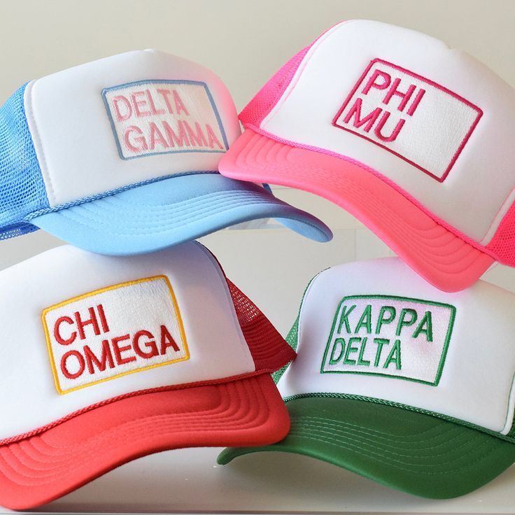 three different colored hats with the words delta gama and chi omega written on them