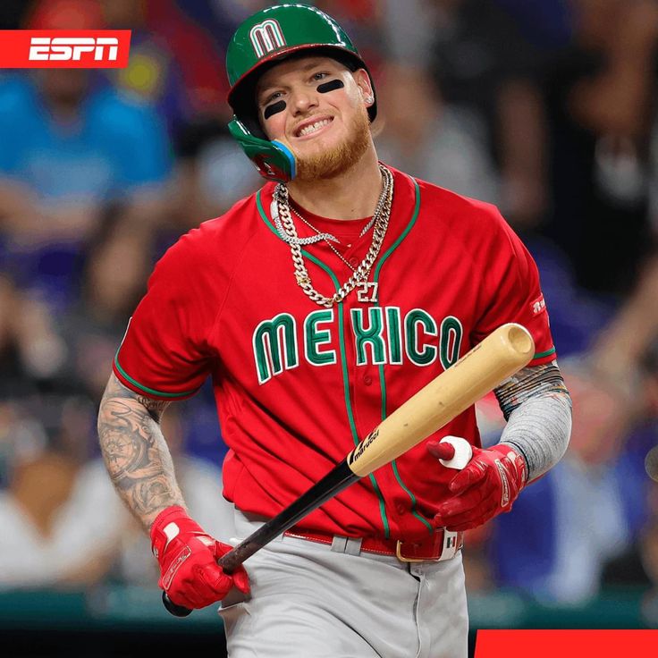 a baseball player is holding a bat and smiling