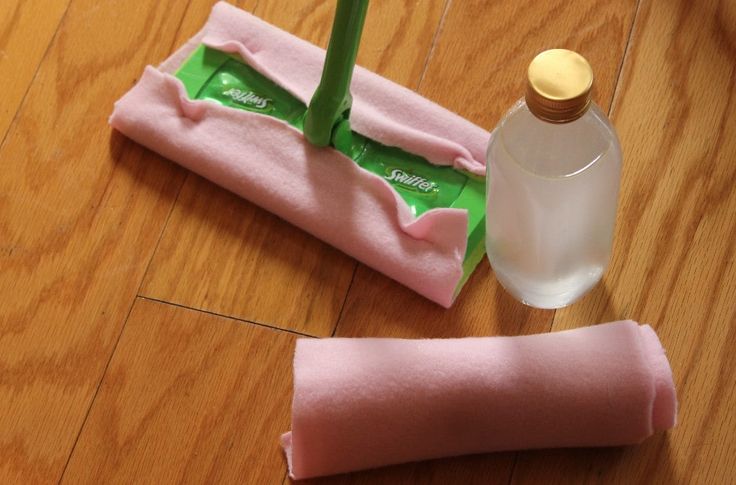 a pair of pink cloths sitting on top of a wooden floor next to a bottle