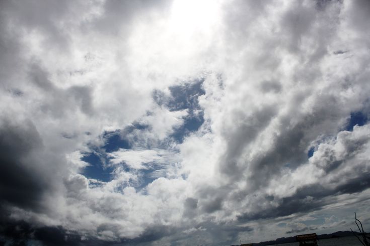 the sky is filled with white clouds and blue water