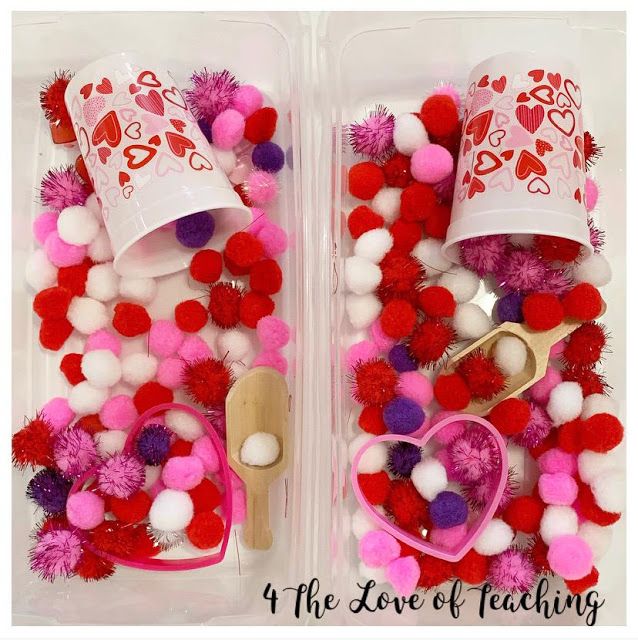 two plastic containers filled with pom poms and hearts