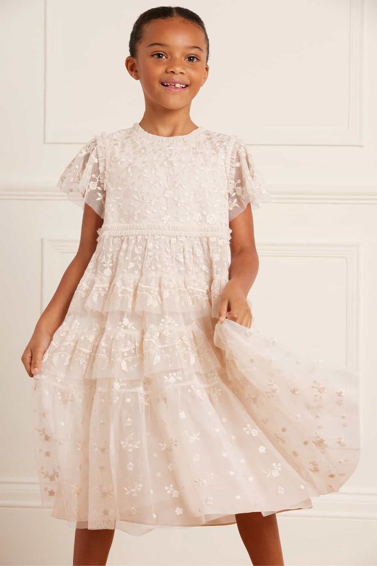 Description and Details The Angelica Lace KIDS in Cream. This elegant dress is designed with intricate embroidery, inspired by Victorian lace trims. Tiered frills add a playful and charming quality to this timeless design. The ultimate addition to your little one's wardrobe. - Tulle decorated all-over with tonal embroidery - 100% Polyester - Fully lined - Grosgrain ribbon trim around waistline - Tulle frill detail around waistline - Concealed zip at centre back - Made in India Care Advice - Deli Luxury Lace Trim Dress For First Communion, Luxury Romantic First Communion Dress With Lace Trim, Tulle First Communion Dress With Lace Trim, Vintage Baptism Dress With Lace Collar, Tulle Skirt Needle & Thread, Tonal Embroidery, Dress Champagne, Victorian Lace, Needle Thread