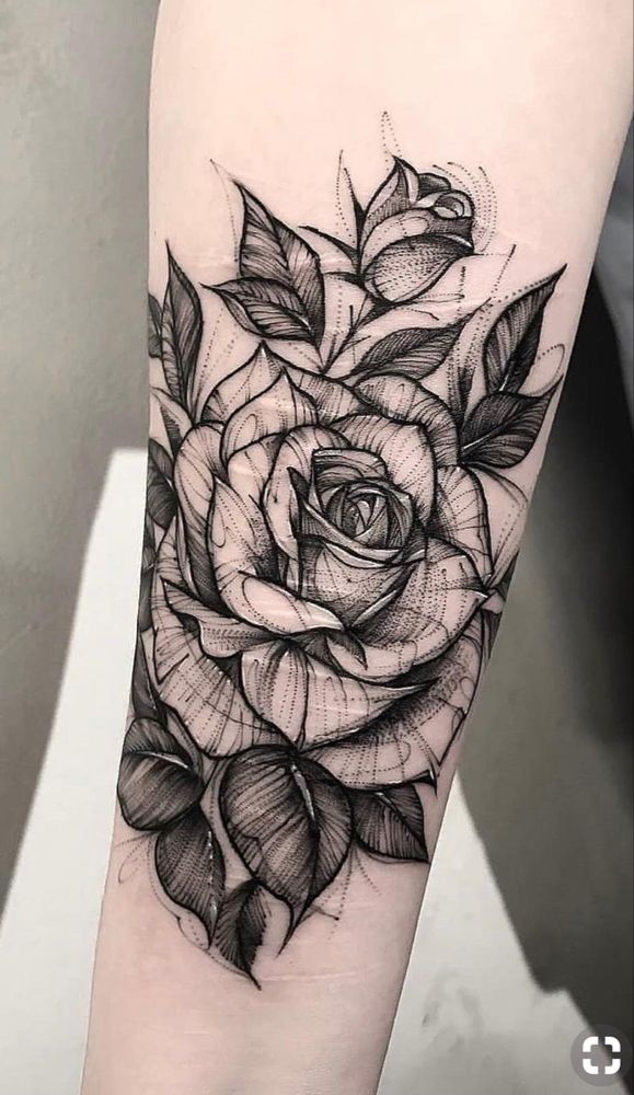 a black and white rose tattoo on the arm