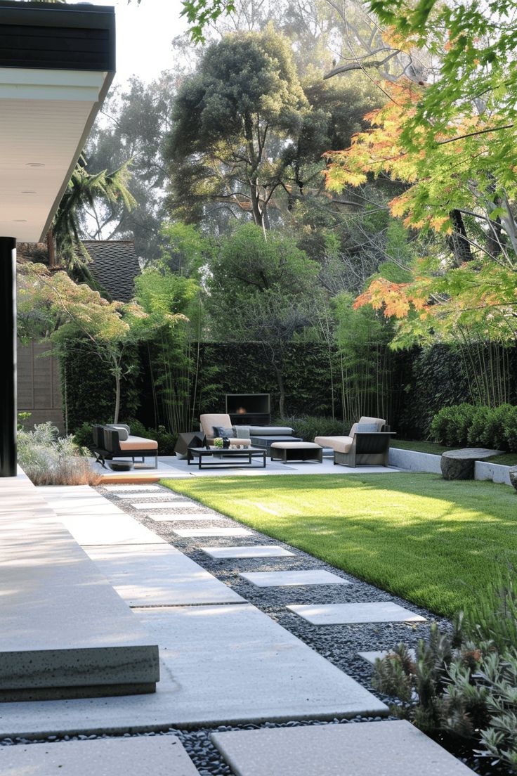 an outdoor patio with grass and stepping stones on the ground, surrounded by trees and bushes