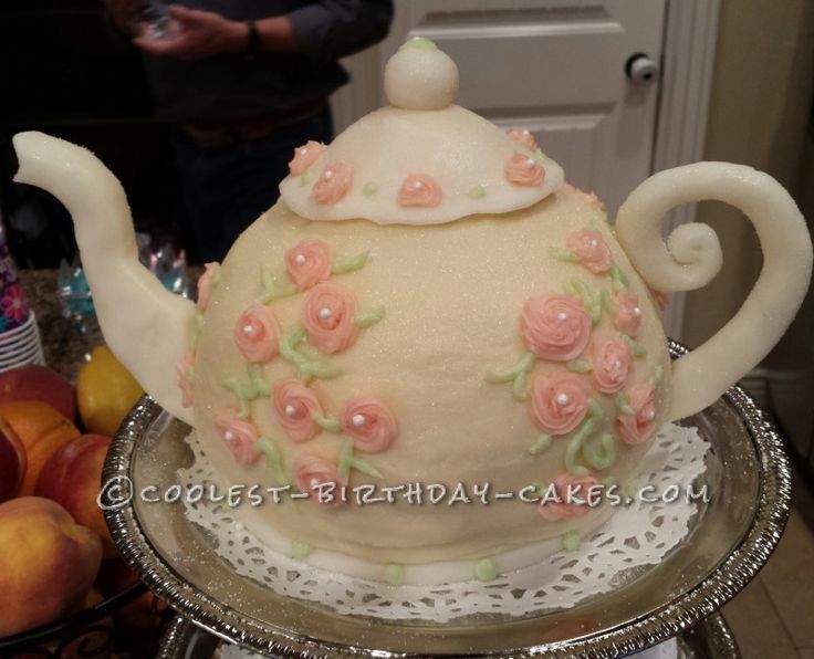 a cake shaped like a teapot with flowers on it