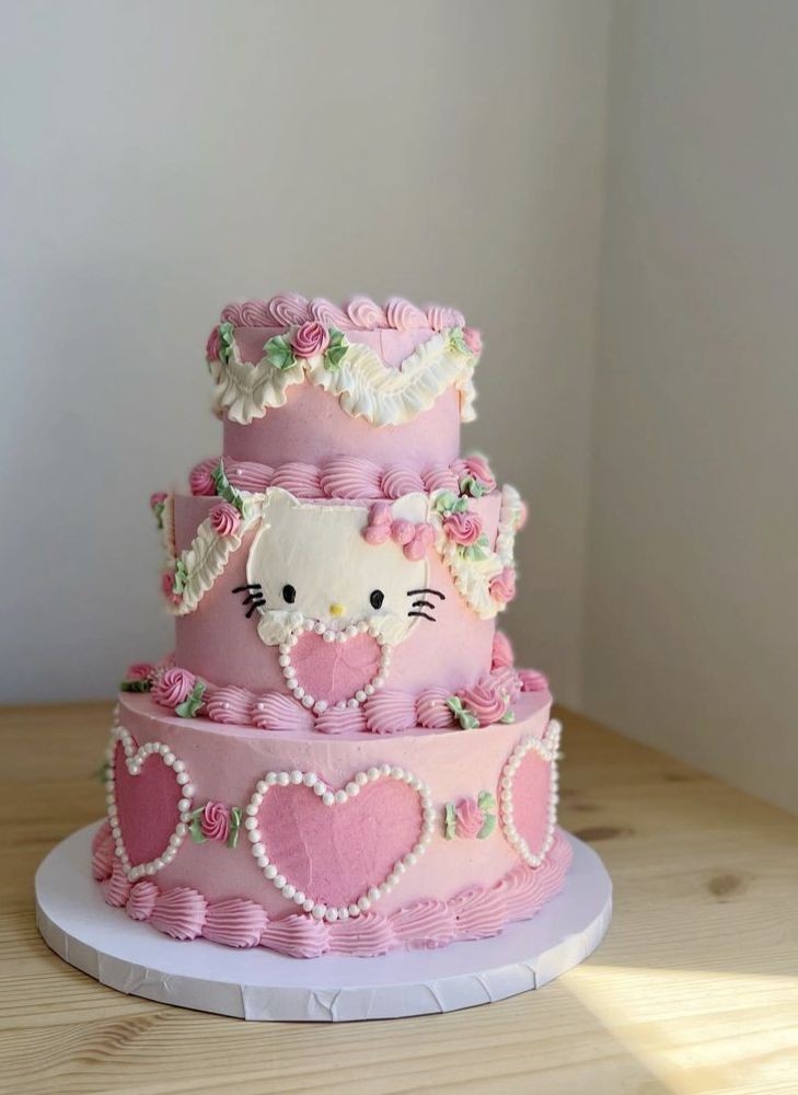 a hello kitty cake with pink frosting and hearts