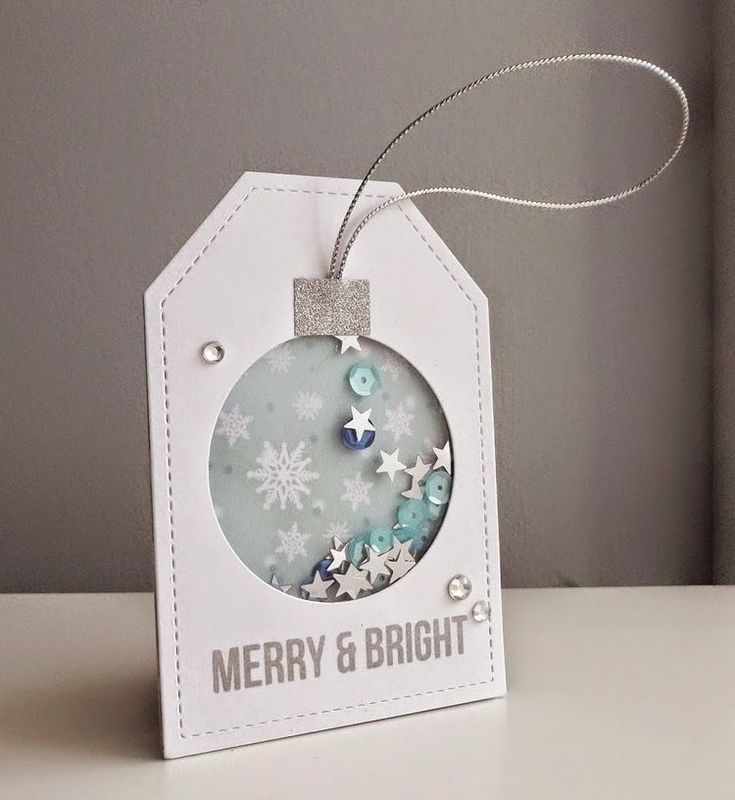 a christmas ornament hanging from a string on top of a white table with snowflakes