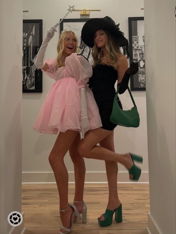 two women in dresses and hats posing for the camera