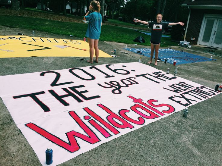 two girls standing next to a large sign