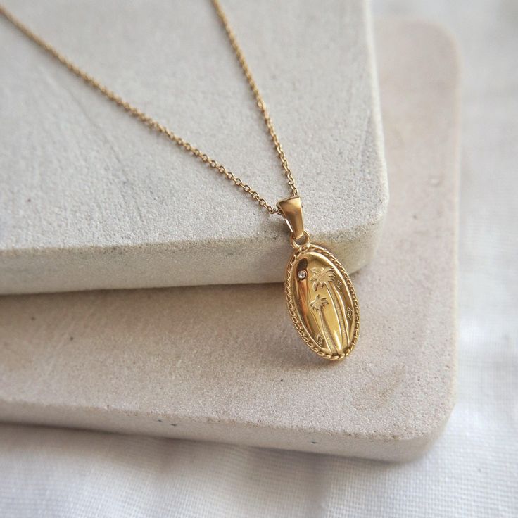 Looking to add some beach vibes to your summer style? Introducing the Palmetto Necklace - featuring a long oval pendant beautifully adorned with palm trees and a delicate cubic zirconia stud. Enjoy a piece of paradise wherever you go, this stunning necklace is perfect for those who love to soak up the sun and feel the sand between their toes. -stainless steel, gold plated -15.5" in length with 2" extender Soak Up The Sun, Oval Pendant, Beach Vibes, Stunning Necklace, Beach Vibe, Jewelry Case, The Sand, Pearl Ring, Pearl Jewelry