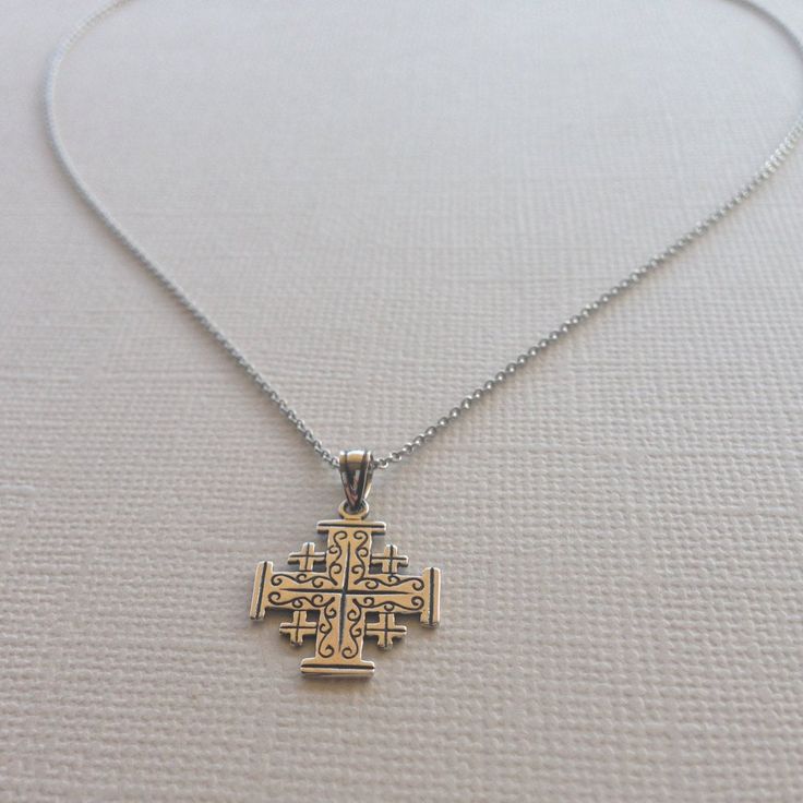 This one of a kind, elegant cross necklace is created entirely in sterling silver. With an intricate design on one side and Jerusalem written on the other, this reversible necklace can be worn multiple ways. Pendant is hand-crafted with an antique finish to bring out the detailing and shine. Item is Nickel-Free and hypoallergenic and comes with a Rhodium Plated Italian Link Chain. This delicate necklace will make the perfect gift for anyone. Material: 925 Sterling Silver Pendant Size: about 0.75 Spiritual Cross Necklace With Intricate Design, Sterling Silver Spiritual Cross Pendant Necklace, Spiritual Sterling Silver Cross Pendant Necklace, Sterling Silver Necklace With Oxidized Cross Pendant, Spiritual Cross Jewelry With Intricate Design, Sterling Silver Crucifix Necklace In Spiritual Style, Sterling Silver Spiritual Crucifix Necklace, Spiritual Sterling Silver Crucifix Necklace, Sterling Silver Cross Necklace With Intricate Design