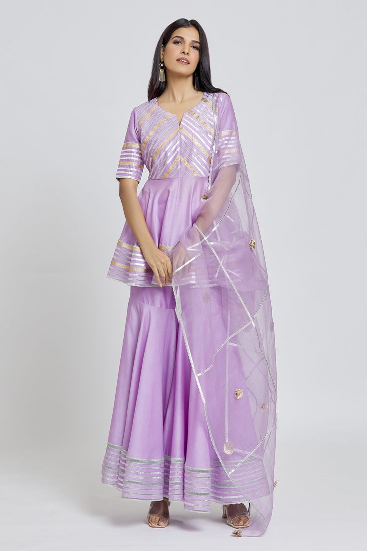 Purple peplum kurta with gota embroidery in striped pattern. Paired with a gharara and dupatta.
Components: 3
Pattern: Embroidered
Type Of Work: Gota
Neckline: Round V
Sleeve Type: Elbow
Fabric: Kurta and Gharara: Silk Chanderi, Dupatta: Organza
Color: Purple
Other Details: 
Gota striped embroidery
Occasion: Mehendi and Haldi - Aza Fashions Bollywood Style Semi-stitched Lehenga With Peplum, Bollywood Purple Palazzo Set For Diwali, Purple Palazzo Set With Gota Work For Eid, Traditional Organza Peplum Sets, Unstitched Purple Sharara With Cutdana, Unstitched Purple Sharara With Gota Work, Anarkali Sharara With Gota Work In Organza, Purple Dori Work Sharara For Eid, Purple Dori Work Sharara For Diwali