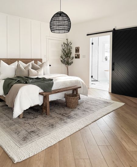 a large bed sitting on top of a wooden floor next to a white wall and door