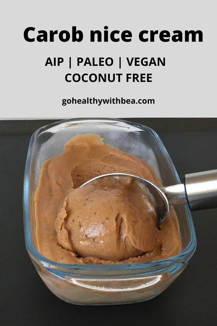 a bowl filled with chocolate ice cream on top of a black table next to a spoon