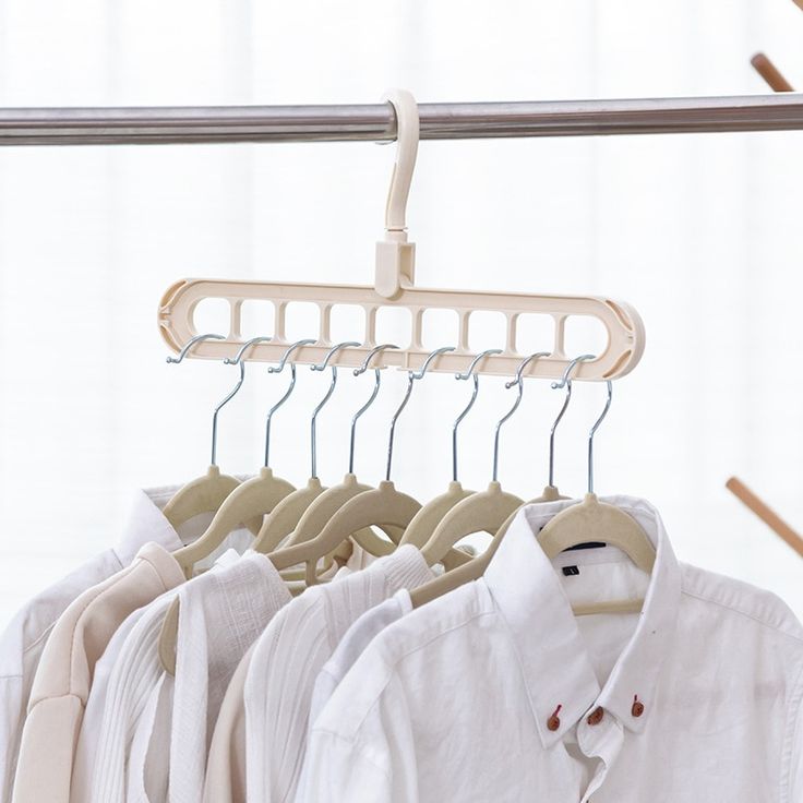 several shirts hanging on clothes racks in front of a window