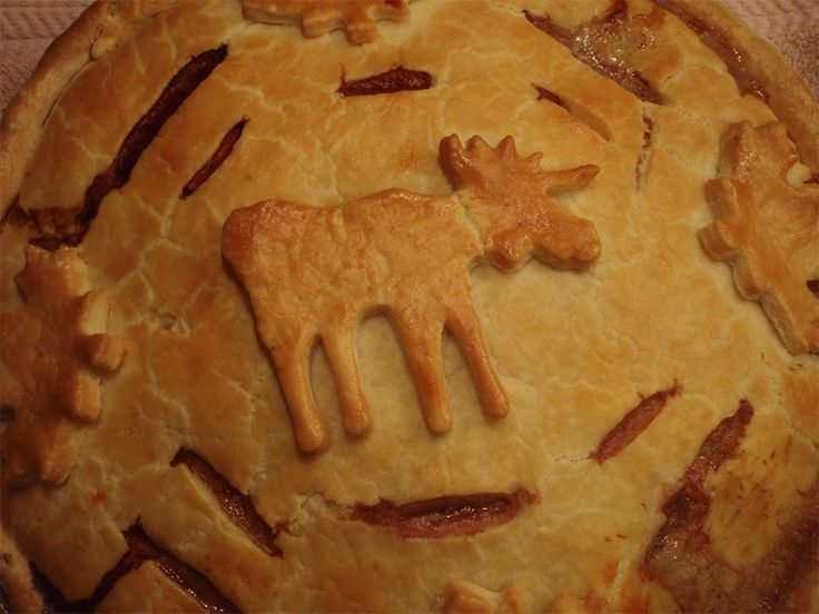 a close up of a pie with animals carved on it's crust and toppings