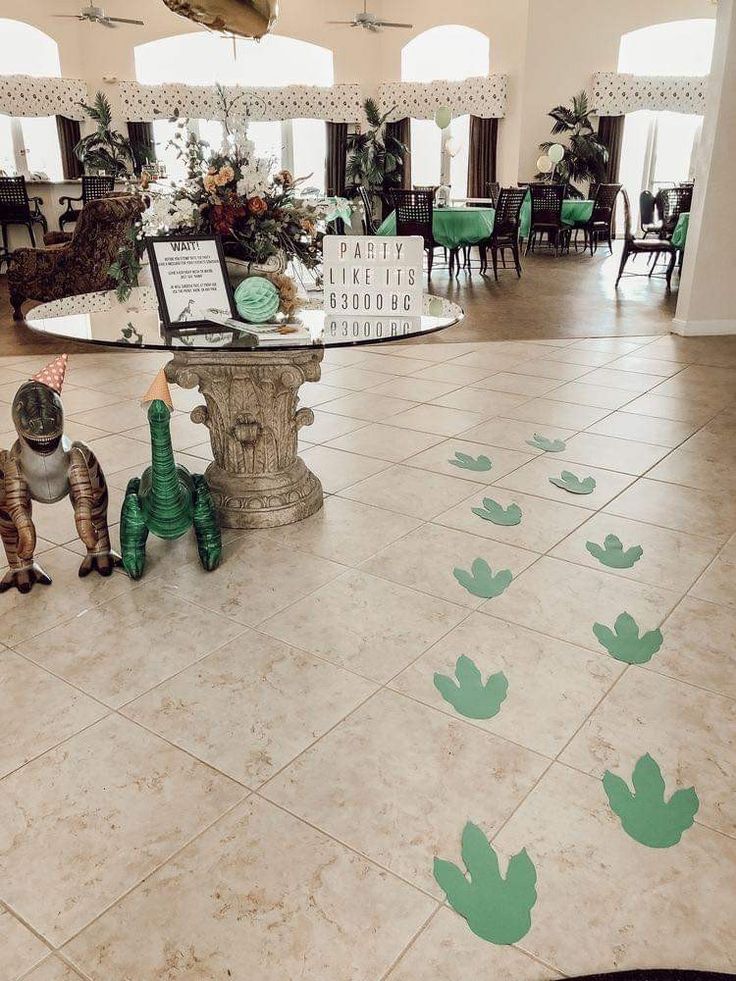 the floor is decorated with green leaves on it, and there are two people standing in front of them