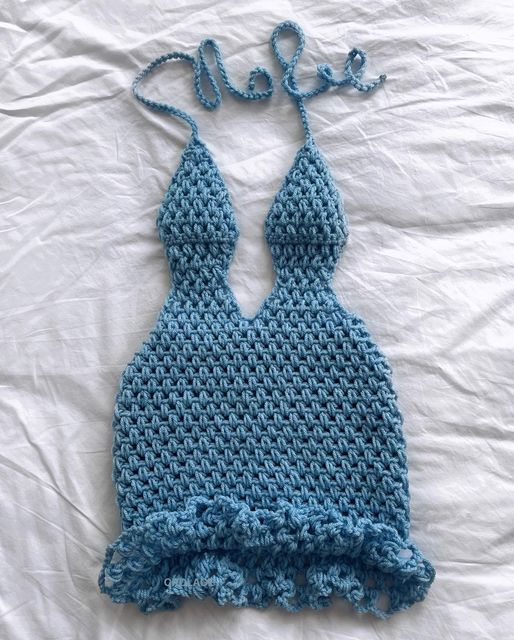 a crocheted bathing suit laying on top of a bed