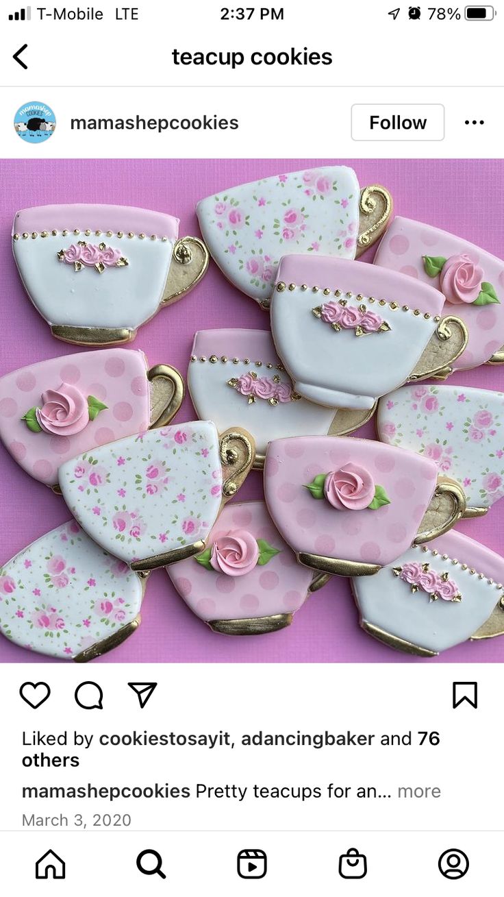 some pink and white teacup cookies are on a purple tablecloth with gold trimmings