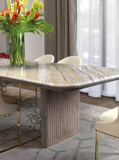 a marble dining table surrounded by chairs and vase with flowers on it in front of a window