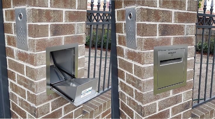 there are two mailboxes on the side of this brick wall and one is open