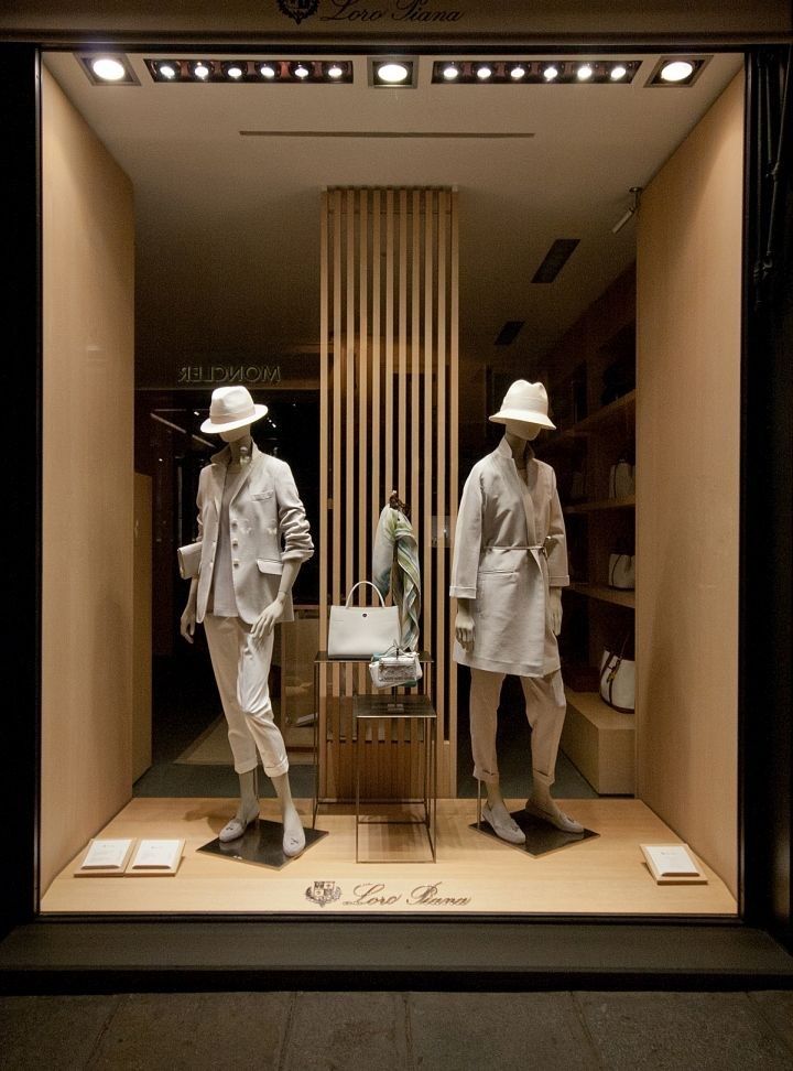 two mannequins dressed in white clothing and hats are standing in a store window