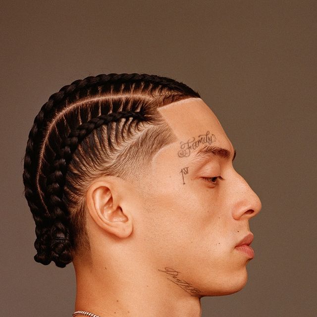 a man with braids and tattoos on his head