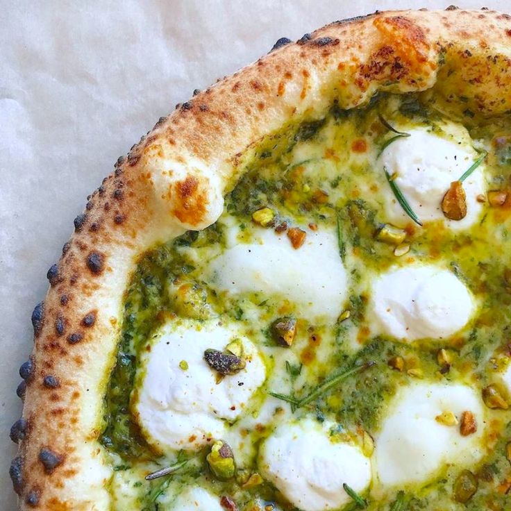 a pizza topped with mozzarella and pesto