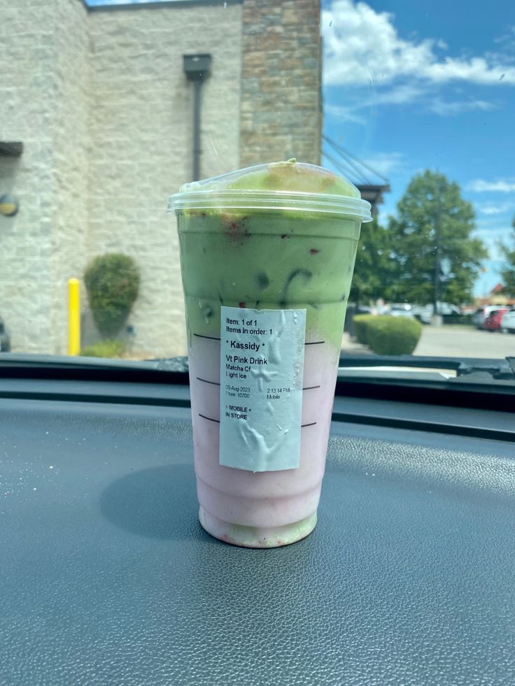 a plastic cup sitting on top of a car dashboard