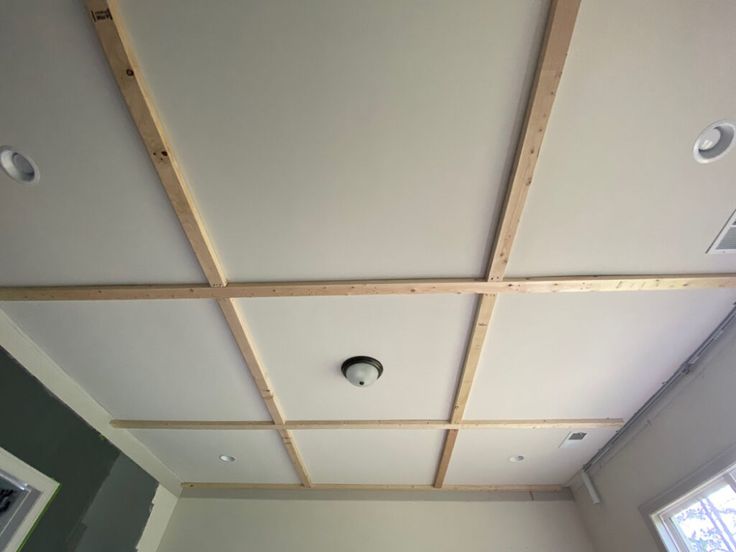 an unfinished ceiling in a room with white walls and wood trimmings on the ceiling