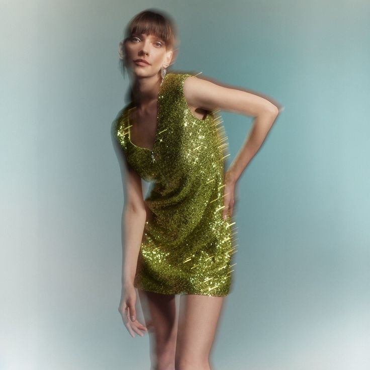 Narni dress is made of green sequin fabric with an A-cut pattern. Narni mini dress with v-neck and metal zipper detail %100 polyester  Dry Clean Only V-neck Mini Dress With Contrast Sequins For Cocktail, V-neck Contrast Sequin Mini Dress For Cocktail, Cocktail V-neck Mini Dress With Contrast Sequin, Green Sequined Mini Dress For Cocktail, Glamorous Green Mini Dress With Contrast Sequin, Green Mini Dress For Beach Party, Cocktail Green Mini Dress With Sequins, Green Mini Dress For Party Season, Glamorous Green Mini Dress