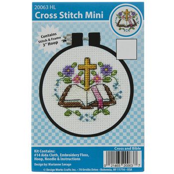 the cross stitch mini kit is shown with an image of a cross and flowers on it